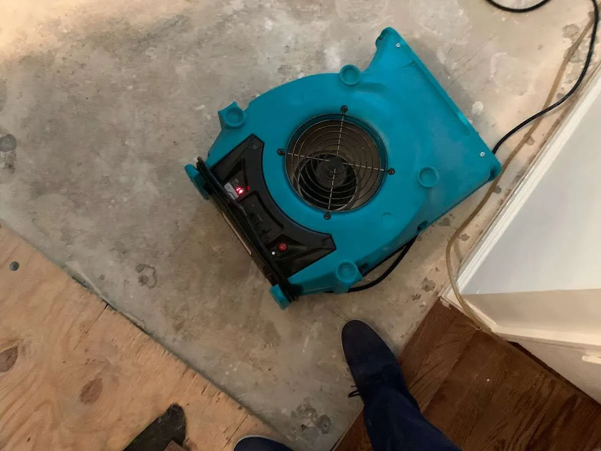 Air mover drying subfloor during Commercial Water Damage Restoration in East Pikeland